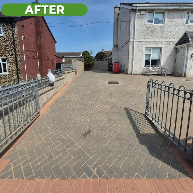 The same gated driveway after cleaning, paving clean and joints clear.
