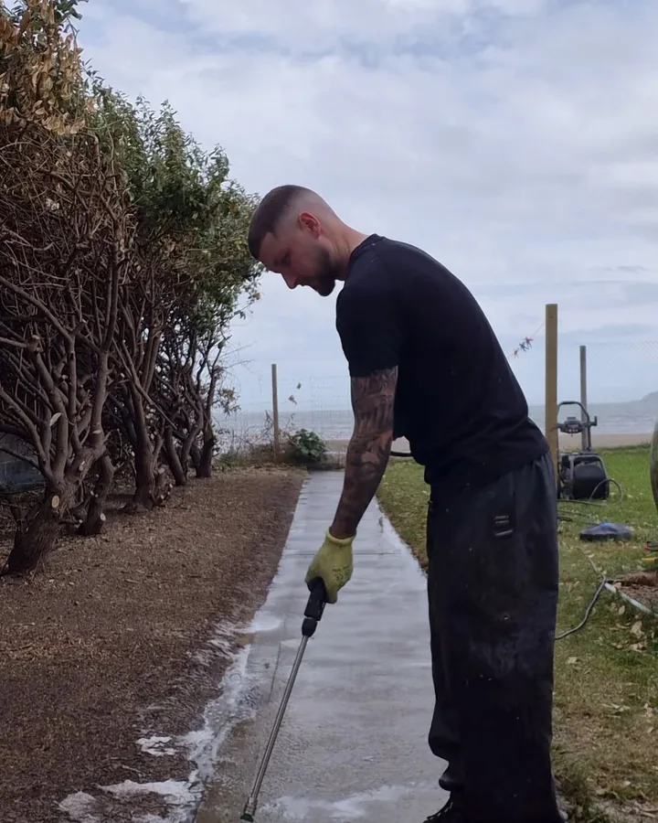 David of ClearScape Exterior Care pressure washing a path.